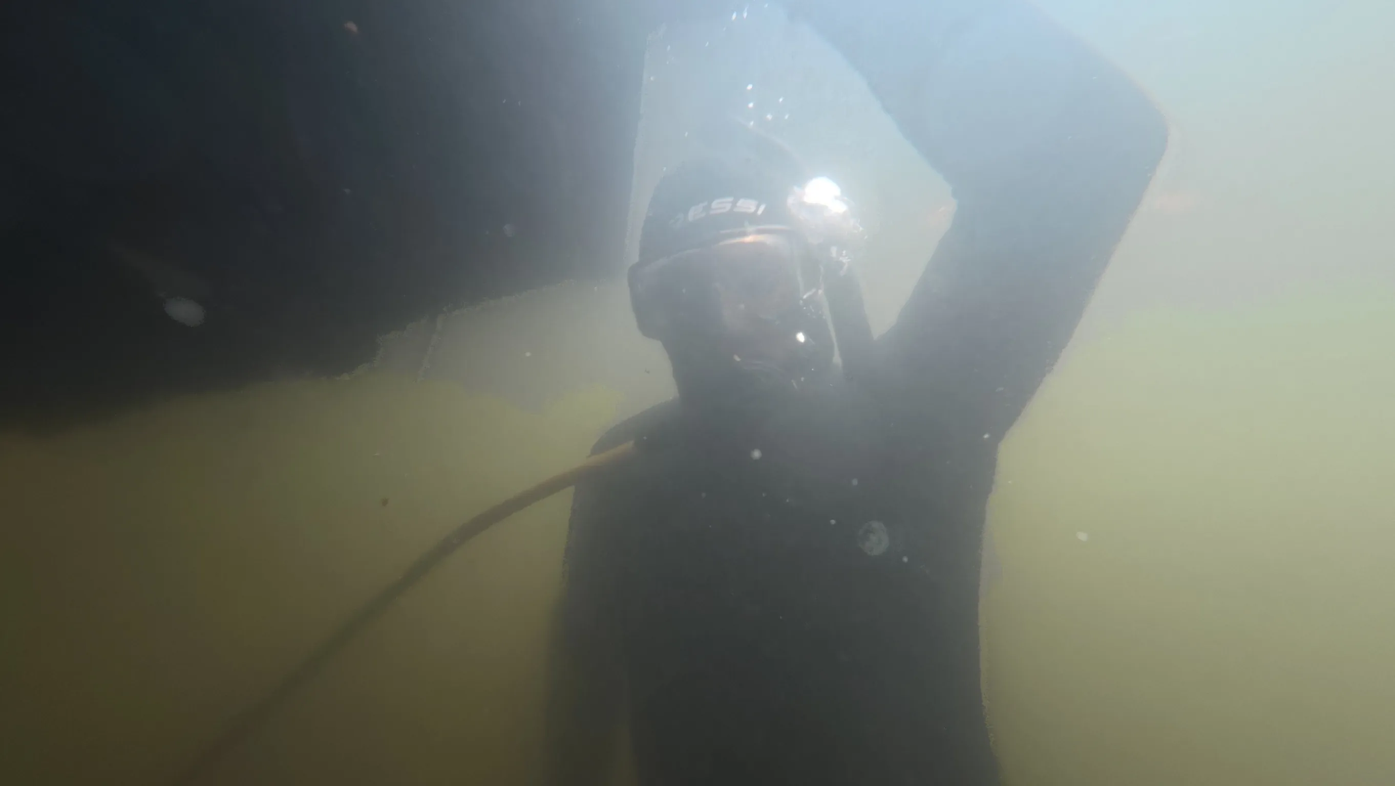 Diver cleaning a center console boat hull at Keystone Point Marina, North Miami