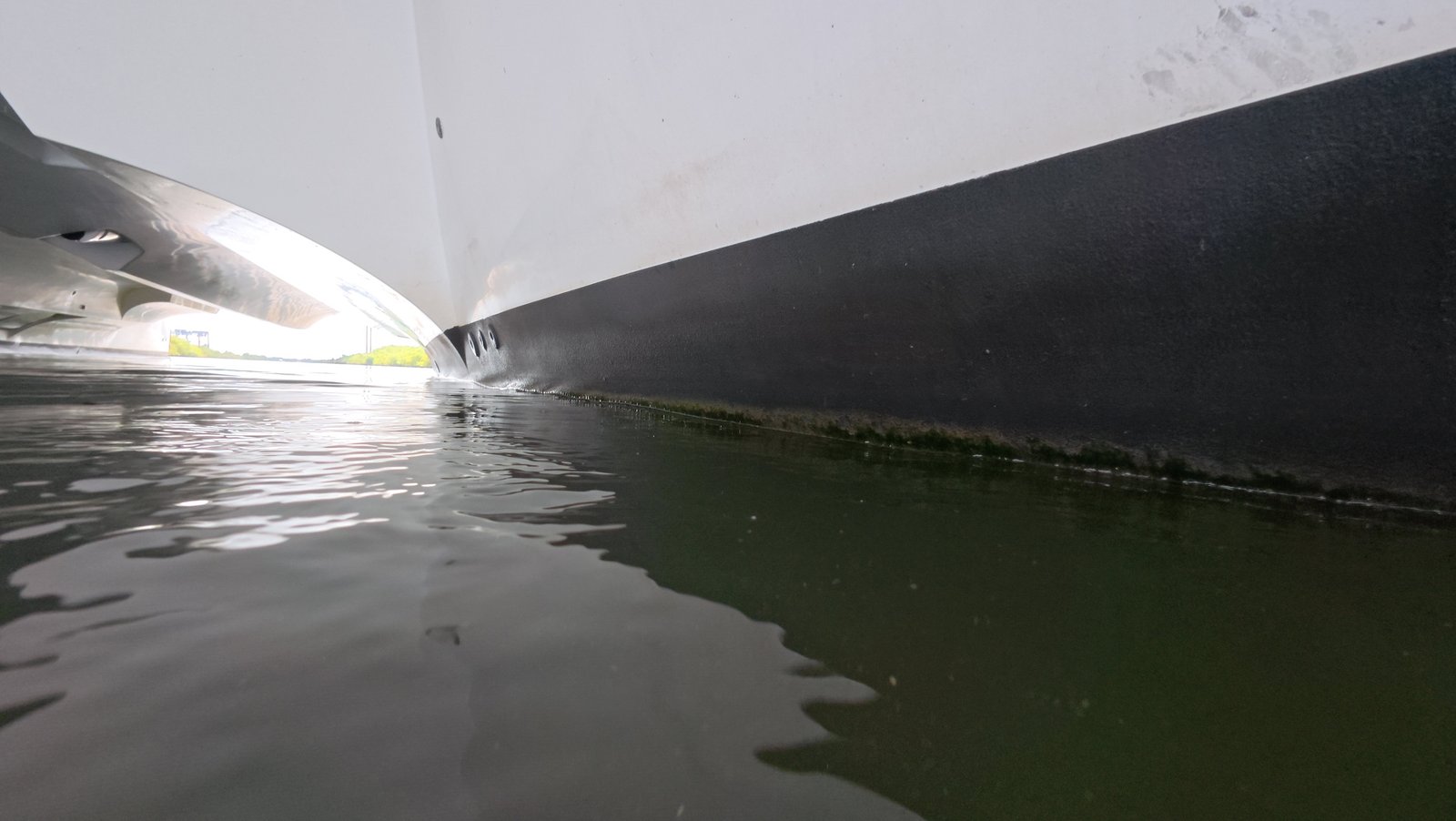 Diver cleaning boat hull underwater in Sunny Isles Beach, FL