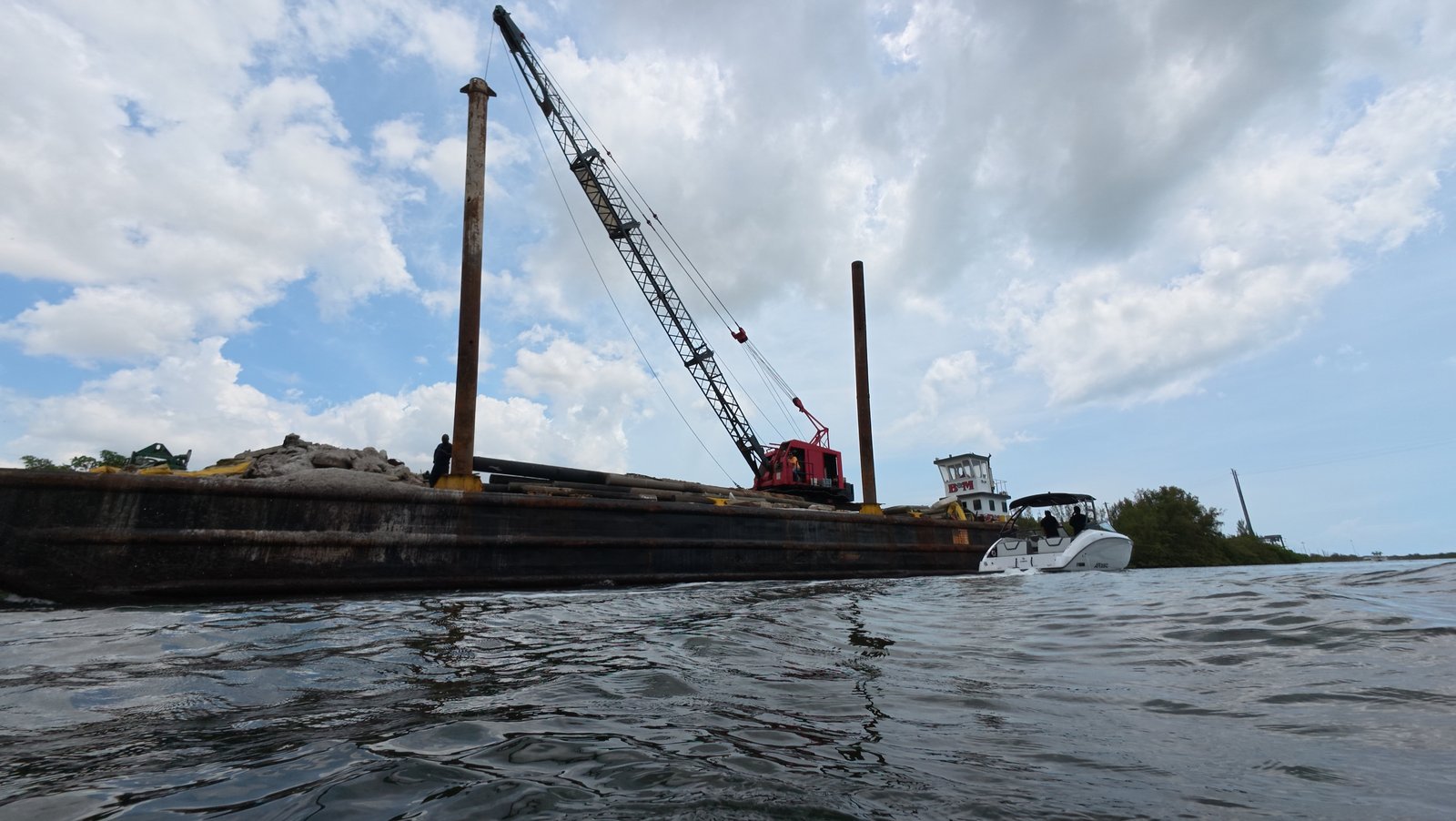 Diver cleaning a sailboat hull underwater at Dinner Key Marina, Coconut Grove
