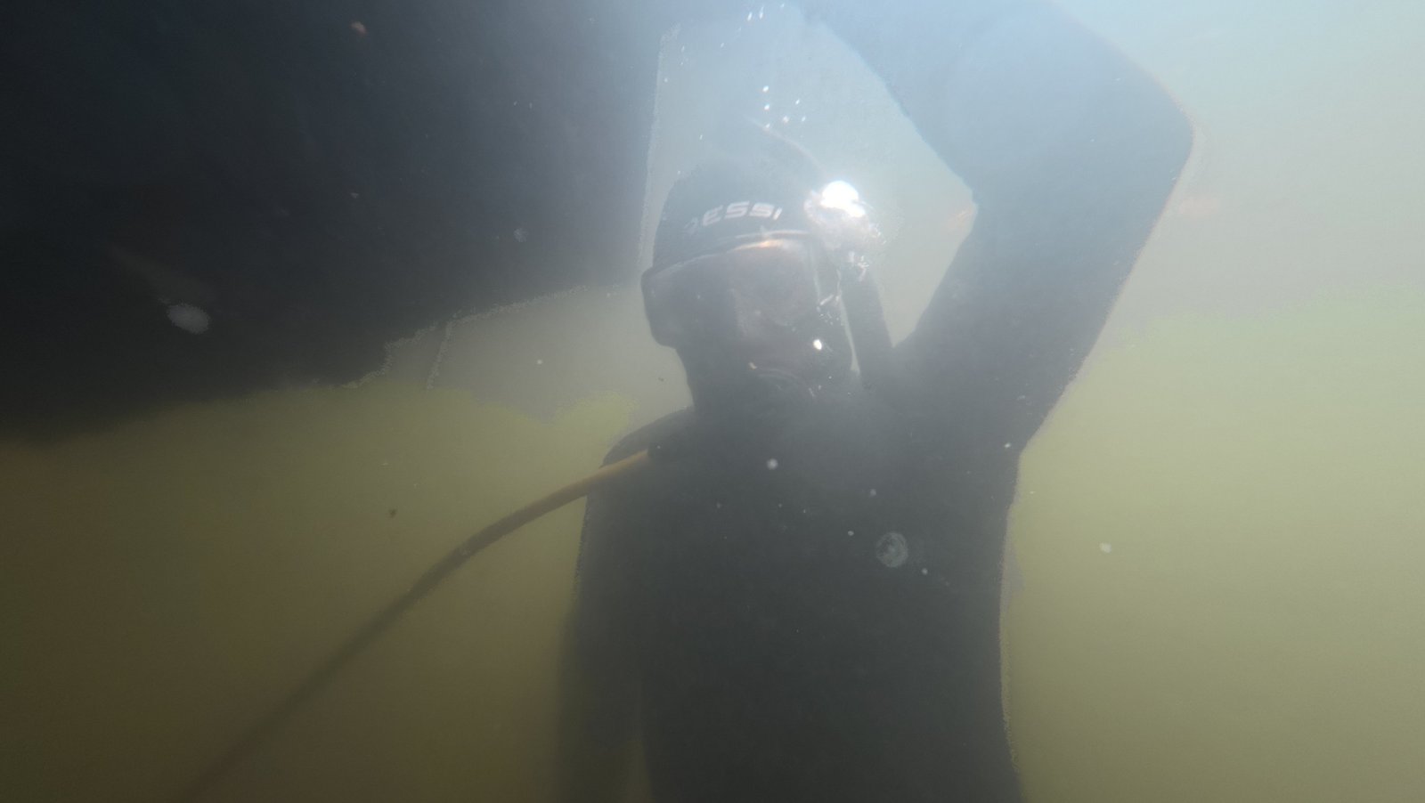 Diver cleaning a center console boat hull at Keystone Point Marina, North Miami